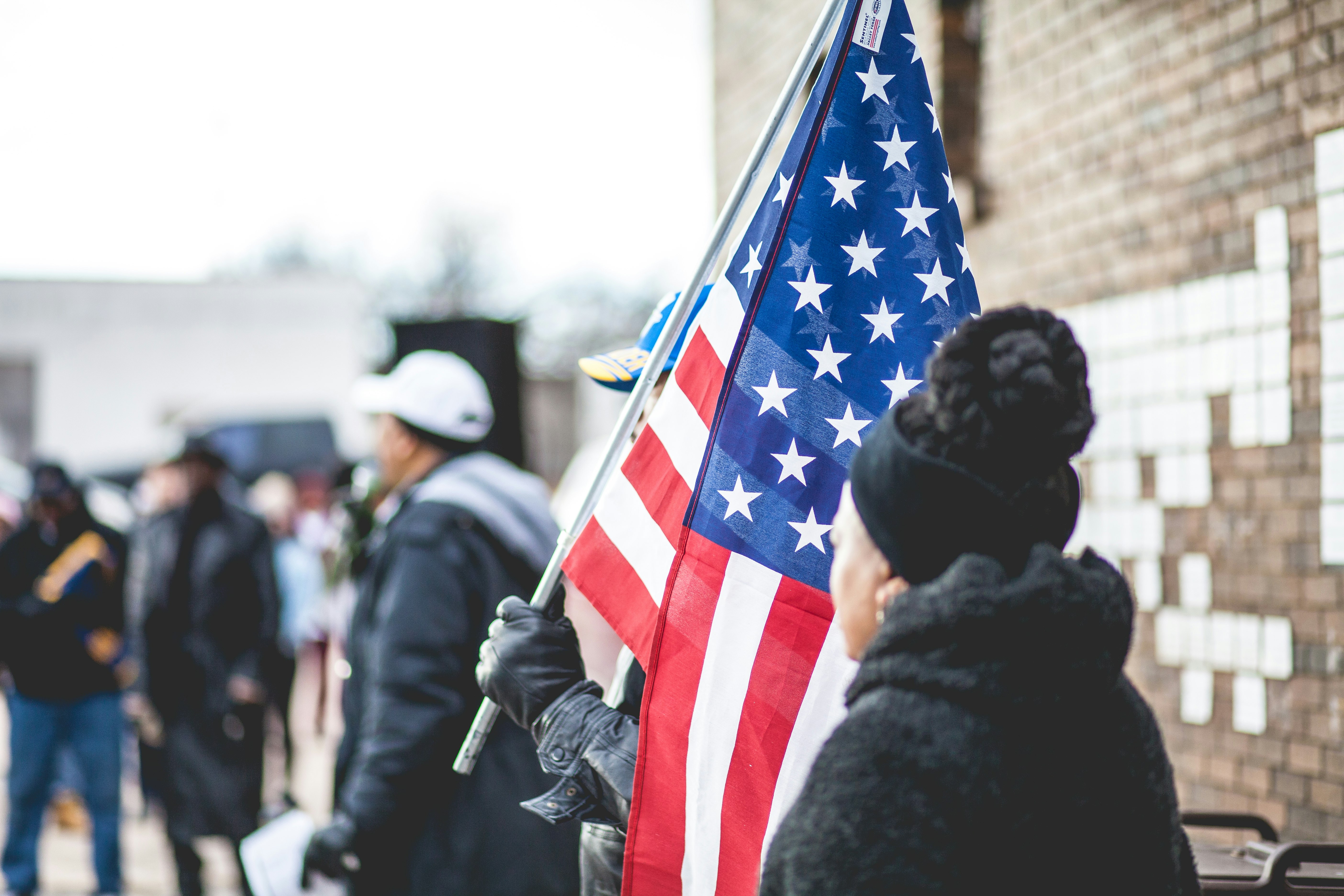 woman standing beside person holding flag of America